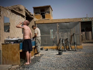 1st Lt. Chris Babcock, front, and Spc. Manuel Salvador, from the 1-320th Alpha Battery, 2nd Brigade of the 101st Airborne Division, wash face and shave at COP Nolen, in the volatile Arghandab Valley, Kandahar, Afghanistan, Sunday, July 25, 2010. (AP Photo/Rodrigo Abd)