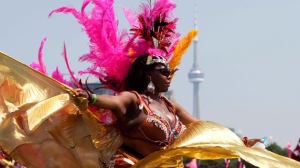 A masquerader performs on Lakeshore Boulevard during the Grand Parade at the Scotiabank Caribbean Carnival in Toronto on Saturday, August 4, 2012. (The Canadian Press/Michelle Siu)