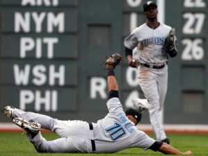 Toronto Blue Jays' Vernon Wells (10) hangs onto the ball for the out on a hit by Boston Red Sox's Victor Martinez as the Blue Jays' Fred Lewis, right, looks on in the fourth inning of a baseball game in Boston, Sunday, Aug. 22, 2010. (AP Photo/Michael Dwyer)